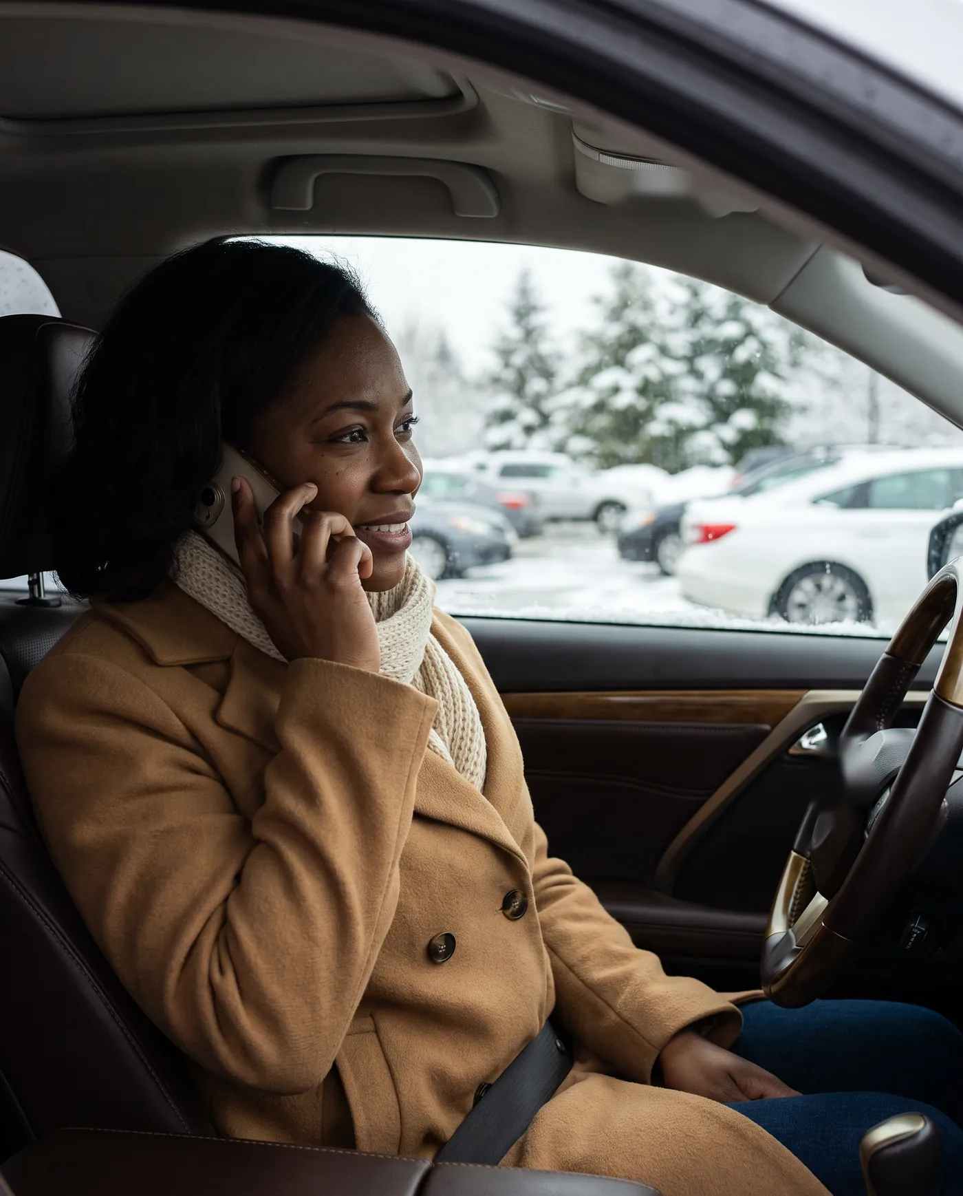 Une cliente, dans sa voiture un après-midi de neige, réserve son rendez-vous au téléphone