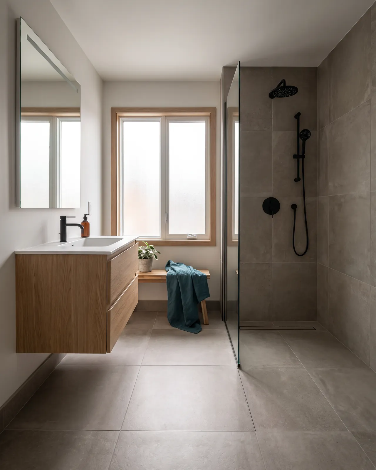 Salle de bain rénovée avec douche sans seuil, drain linéaire et meuble-lavabo en chêne
